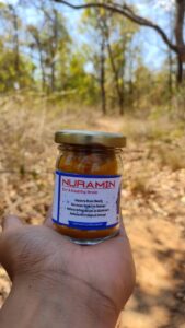 n image of Nuramin, a turmeric-based food supplement developed by Bagdara Farms, showing a yellow-orange powder in a clear glass jar.