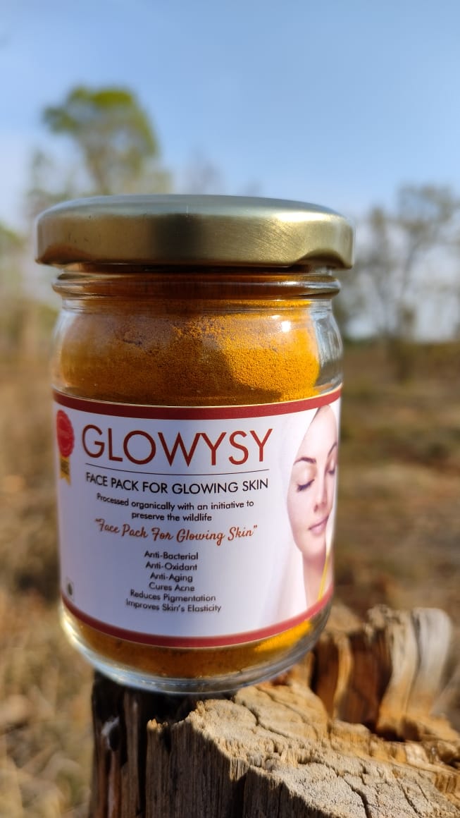 Image of a bottle of Glowysy, a turmeric-based face pack from Bagdara Farms. The bottle has a white label with green text and a green cap. The product is made from pure turmeric root and is a dietary supplement for glowing skin