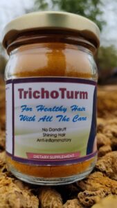 Trichoturm: A natural turmeric-based dietary supplement in a white bottle with a green label and a clear cap, with turmeric roots and leaves in the background
